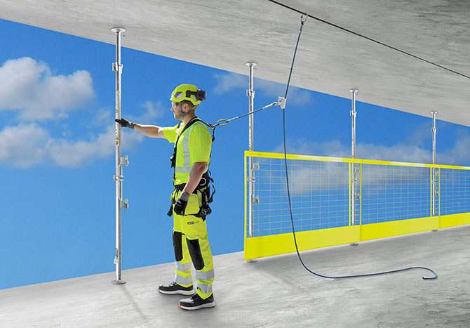 compression posts with fall protection barriers between concrete slabs at construction site